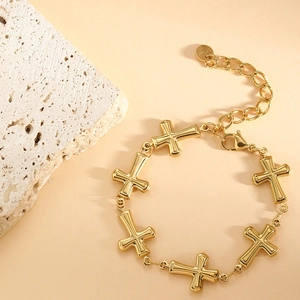 Detail of gold stainless steel bracelet showing 3D cross charms and S.Steel hallmark tag