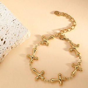 Detailed view of golden stainless steel bracelet with cross links and lobster clasp