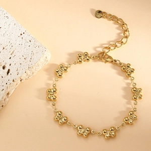 Close-up of golden hollow clover link bracelet with lobster clasp and S.Steel tag