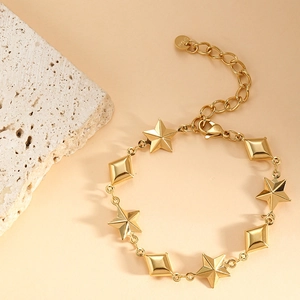Detail of gold star and diamond charms on a stainless steel bracelet with lobster clasp