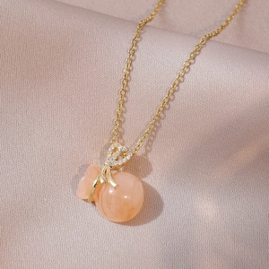 Golden necklace with peach marble money bag pendant and sparkling zircon details