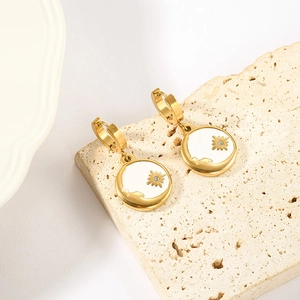 Golden stainless steel starburst hoop earrings with white enamel and sparkling crystal