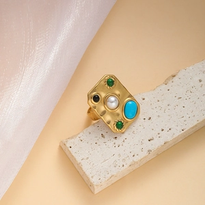Bague vintage dorée avec perle blanche et pierre turquoise sur anneau en métal martelé