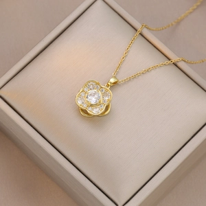Dettaglio della collana con ciondolo a fiore dorato e zirconi in una confezione regalo
