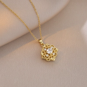 Dettaglio della collana a fiore geometrico dorato con zircone quadrato su seta champagne