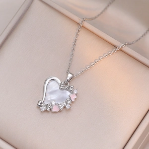 Elegante hartketting met parelmoer en strikdetail in een sieradendoosje