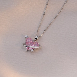 Collier planète cœur rose en acier titane avec zircon sur fond de soie élégant
