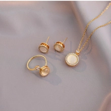 Detail van elegante vergulde sieradenset met crème ronde stenen en glanzende zirconen