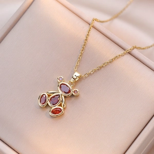 Close-up of golden bear pendant with amber zircon on pink silk jewelry box padding
