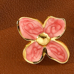 Macro detail of a four-petal flower earring with pink resin rose petals and golden trim