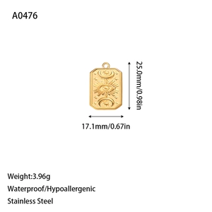Detail of a golden stainless steel rectangular pendant with sun and moon embossed design