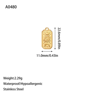 Macro view of gold celestial rectangle pendant in stainless steel showing sun and moon details