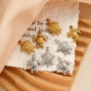 Détails macro de pendentifs tortue en or et argent sur bois élégant et soie douce
