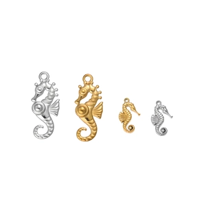 Détail macro de pendentifs hippocampe en or 18 carats et argent avec textures gravées