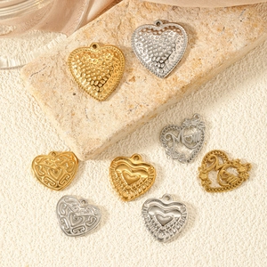 Golden and silver heart pendants in hammered, filigree, and Mom styles on textured stone
