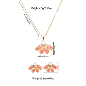 Detailed view of pink floral enamel jewelry set with pearl centers and gold plating