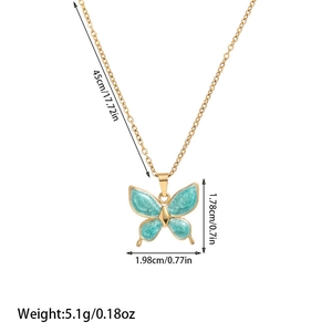 Macro detail of gold butterfly pendant with blue marble enamel wings and size specs