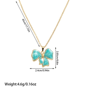 Detailed view of gold chain necklace with blue enamel bow pendant and size measurements