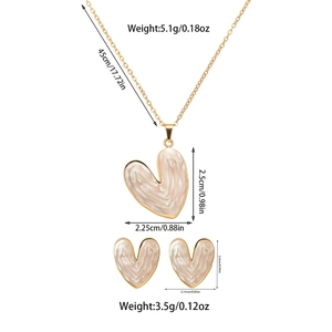 Detailed dimensions of heart-shaped gold necklace and earrings set with pearl white enamel