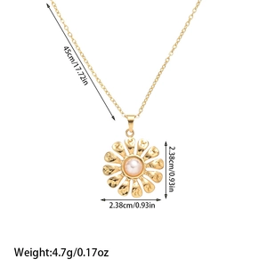 Detailed macro view of a golden daisy pendant with hammered texture and a central pearl