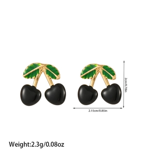 Detail view of cherry earrings with black globes, golden stems, and green leaves