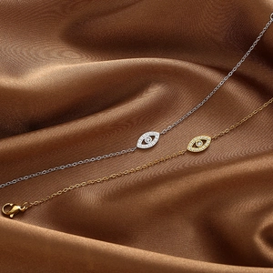 Elegante Halsketten mit Teufelsauge-Motiv und Zirkon auf dunklem Seidenhintergrund