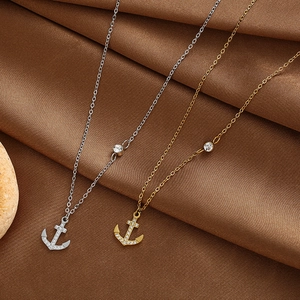 Detailansicht der Ankerkette in Gold und Silber mit Zirkonia auf Seidenstoff