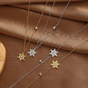 Detailansicht der nautischen Steuerrad-Anhänger in Gold und Silber mit Kristallen