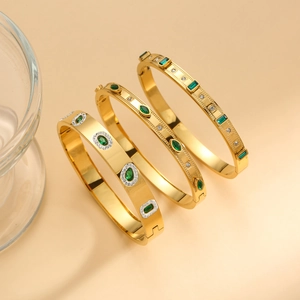Set of three gold polished titanium steel bracelets with emerald green stones and zircon