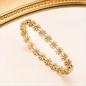 Detailed view of a gold daisy bracelet with sparkling crystal centers and relief craftsmanship