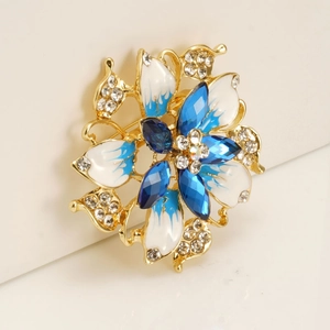Luxurious floral brooch with gold finish, blue gradient enamel petals and sparkling crystals