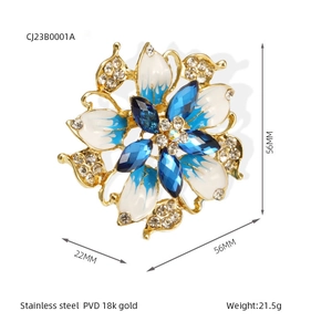 Detail view of flower brooch with 18k gold PVD plating, crystals and blue enamel, 56mm size