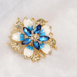 Macro shot of luxury floral brooch with blue enamel petals and sparkling rhinestones