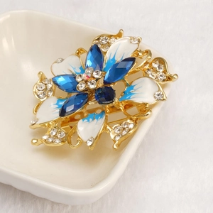 Luxury floral crystal brooch with blue enamel and sparkling rhinestones on golden base