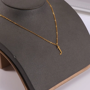 Detailed view of lowercase letter j pendant in 18K gold plated stainless steel