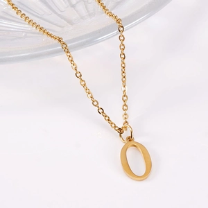 Detail shot of the polished 18K gold letter O pendant on a fine stainless steel chain