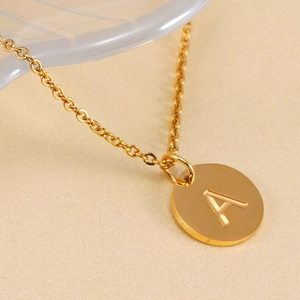 Close-up of 18K gold plated stainless steel necklace featuring a round letter A pendant