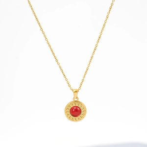 Dettaglio della collana d'oro con pietra rossa e motivo a meandri greci incisi