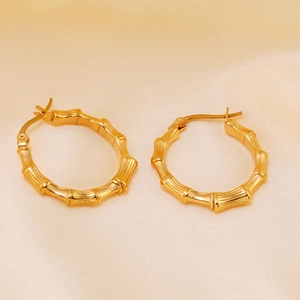 Detalle de los pendientes de aro en forma de C con textura de bambú bañados en oro 18K