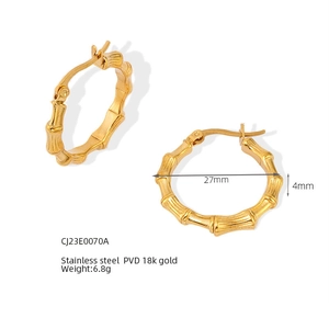 Vista detallada de pendientes de bambú en forma de C con diámetro 27mm y oro de 18 quilates