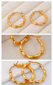 Detalle de pendientes de aro dorados con diseño de bambú en un estuche de joyería