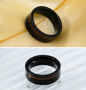Detail view of black tungsten men's ring with real wood inlay on elegant gold silk fabric