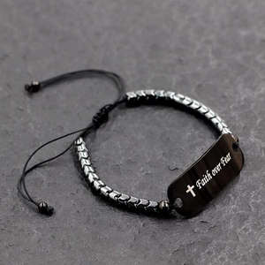 Close-up of Faith over Fear engraved bar on a hematite beaded bracelet with black cord