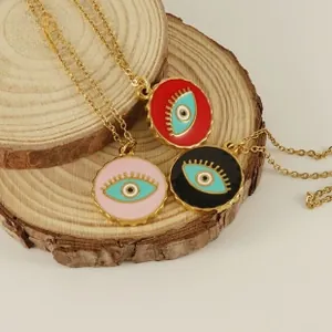 Detalle del conjunto de collares de ojo turco chapados en oro 18K sobre madera