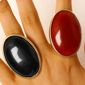 Close-up of large vintage oval resin rings in black and red with gold-tone borders
