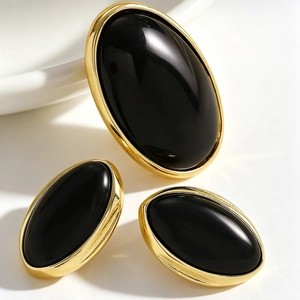 Macro view of vintage oval resin earrings with polished black stones and gold frames