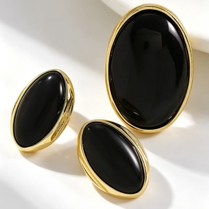 Detail shot of elegant retro gold oval earrings and ring with black resin stones