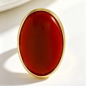 Detailed macro shot of a retro minimalist oval stud earring with red resin and gold frame