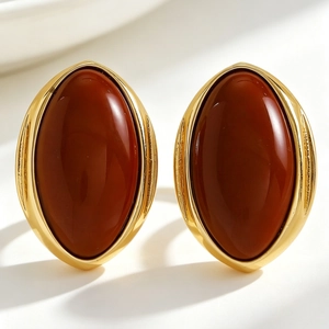 Close-up of vintage oval resin stud earrings with elegant gold geometric frames