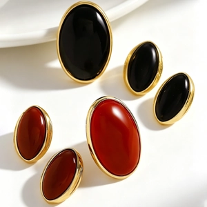 Macro view of vintage resin oval stud earrings in black and red with gold frames.